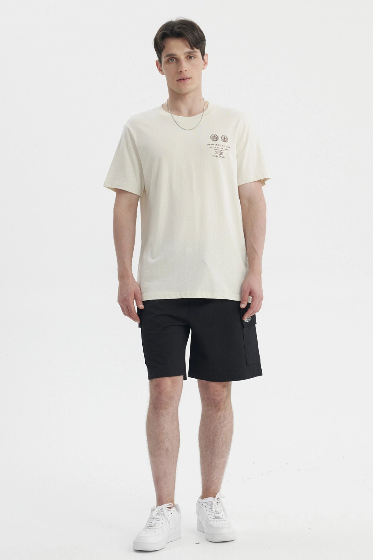 Polera oversize beige para hombre con estampado gráfico pequeño en el pecho a la izquierda