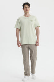 Polera oversize verde claro hombre con texto Serenity Bay en el pecho diseño minimalista y estilo casual relajado