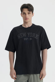 Polera negra de hombre con corte slim y estampa New York Est 91 en el pecho estilo urbano y letras grandes