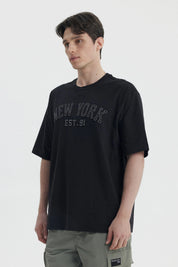 Polera negra de hombre con corte slim y estampa New York Est 91 en el pecho estilo urbano y letras grandes