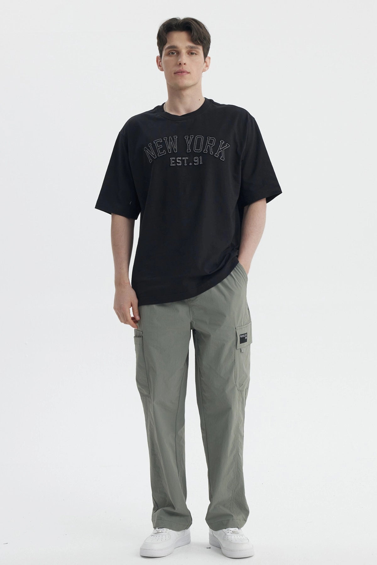 Polera negra de hombre con corte slim y estampa New York Est 91 en el pecho estilo urbano y letras grandes