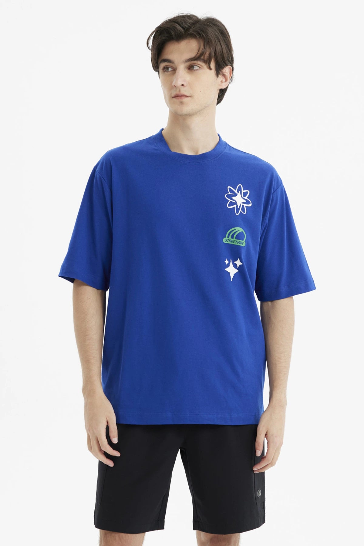 Polera oversize azul para hombre con estampas de flores y texto Street Vibes en el pecho estilo gráfico moderno