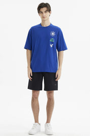 Polera oversize azul para hombre con estampas de flores y texto Street Vibes en el pecho estilo gráfico moderno