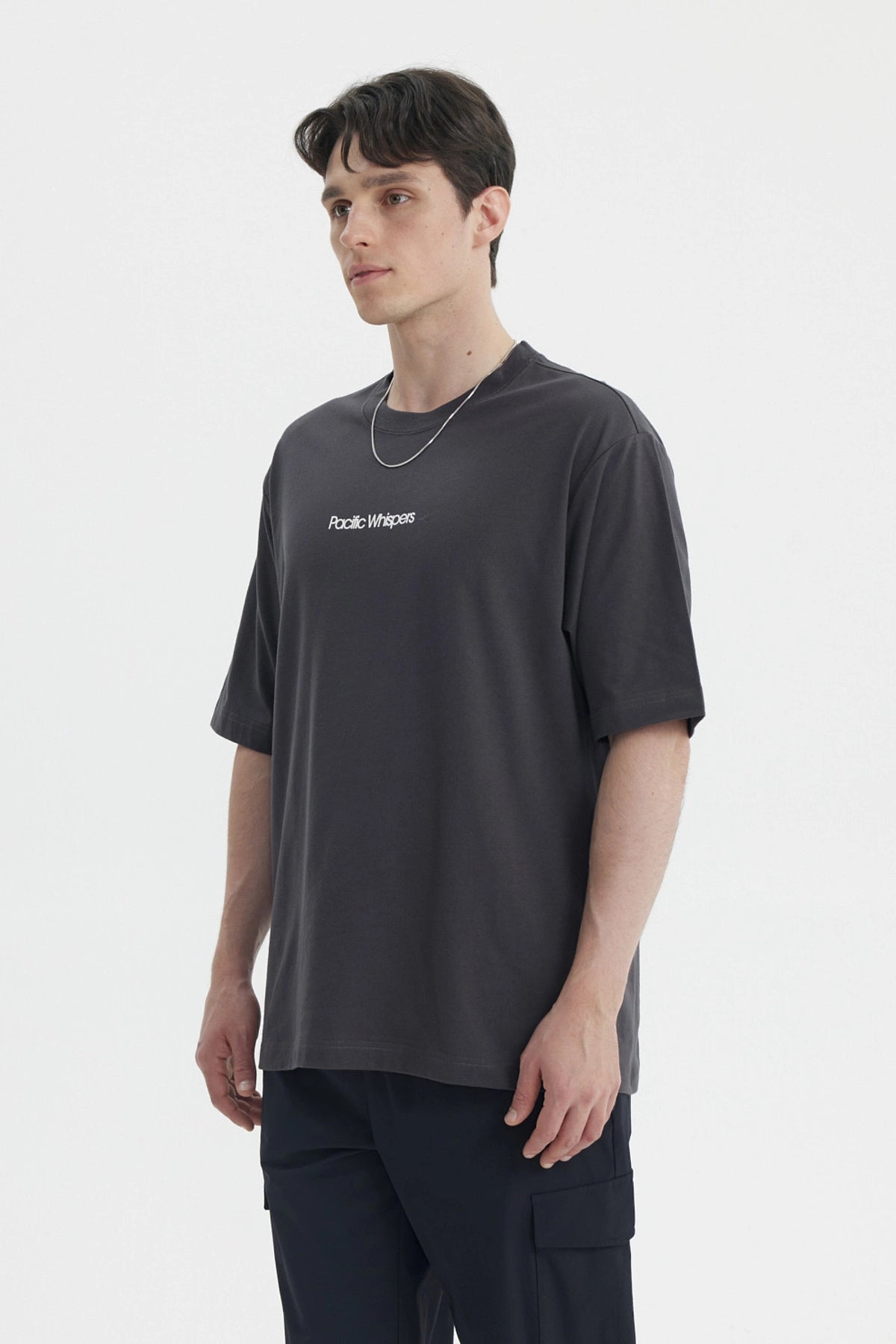 Polera oversize marengo para hombre con texto Pacific Whispers en el pecho estilo casual moderno