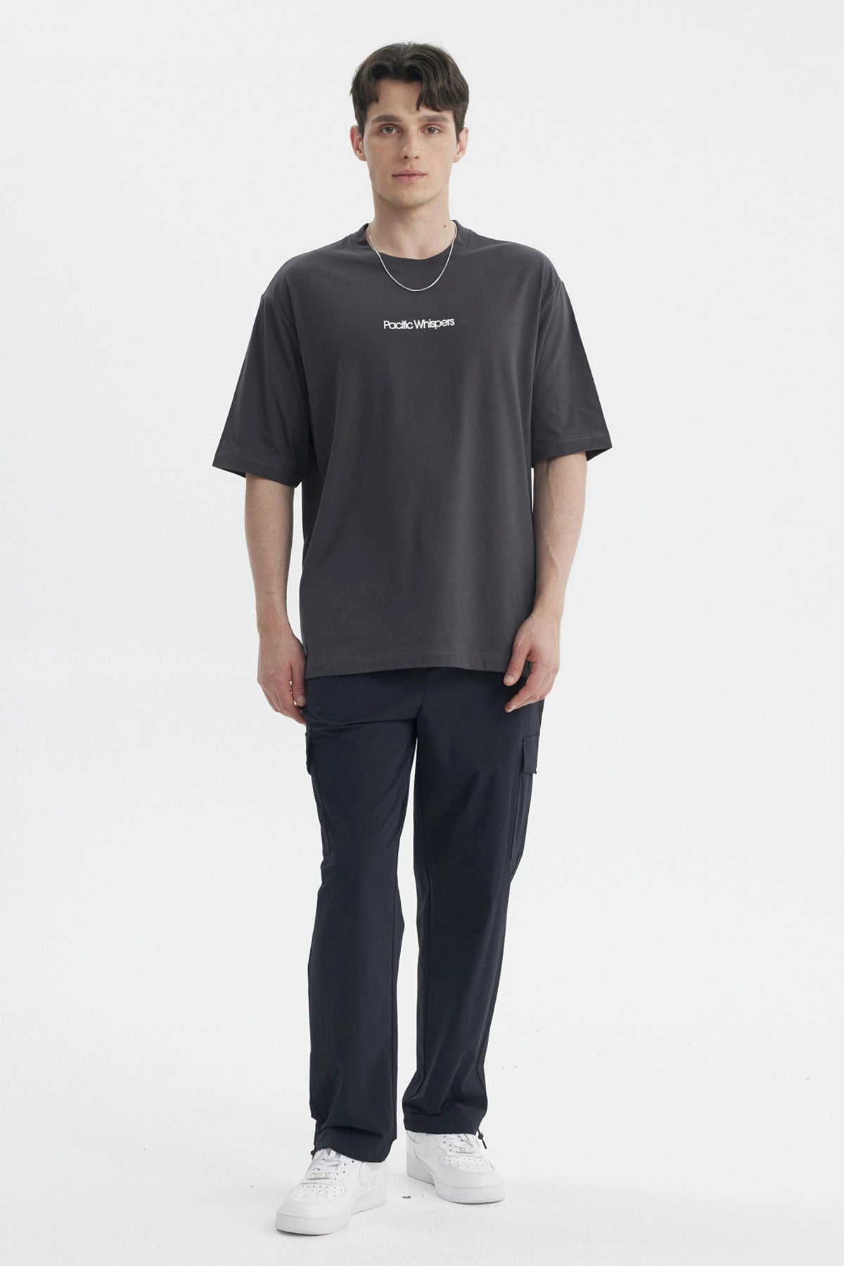 Polera oversize marengo para hombre con texto Pacific Whispers en el pecho estilo casual moderno