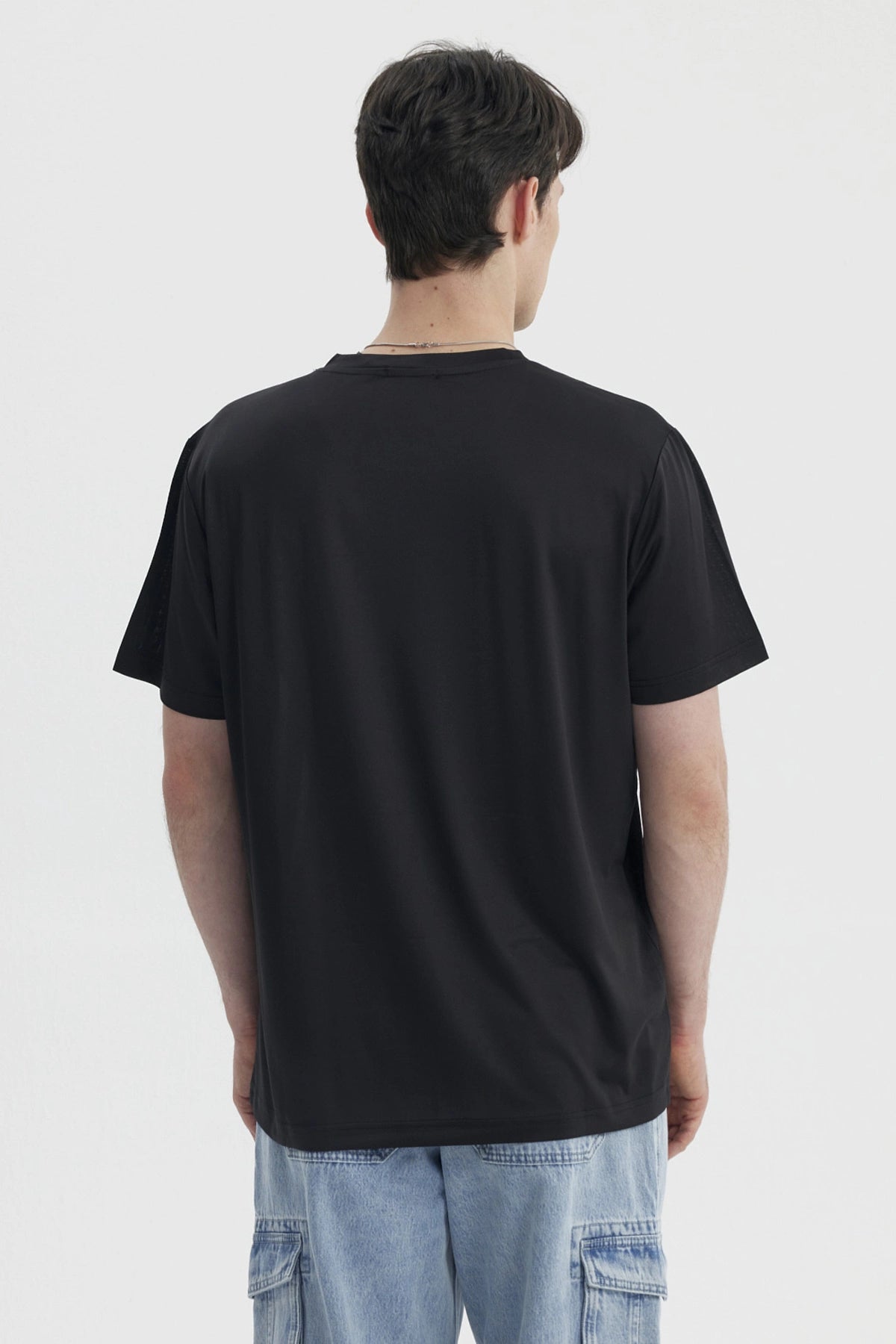 Polera negra para hombre estilo slim con pequeño logo blanco en el pecho izquierdo