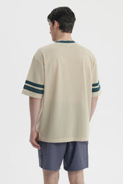 Polera oversize beige de hombre con cuello en V y mangas cortas lleva estampado Break y número 5 en el frente