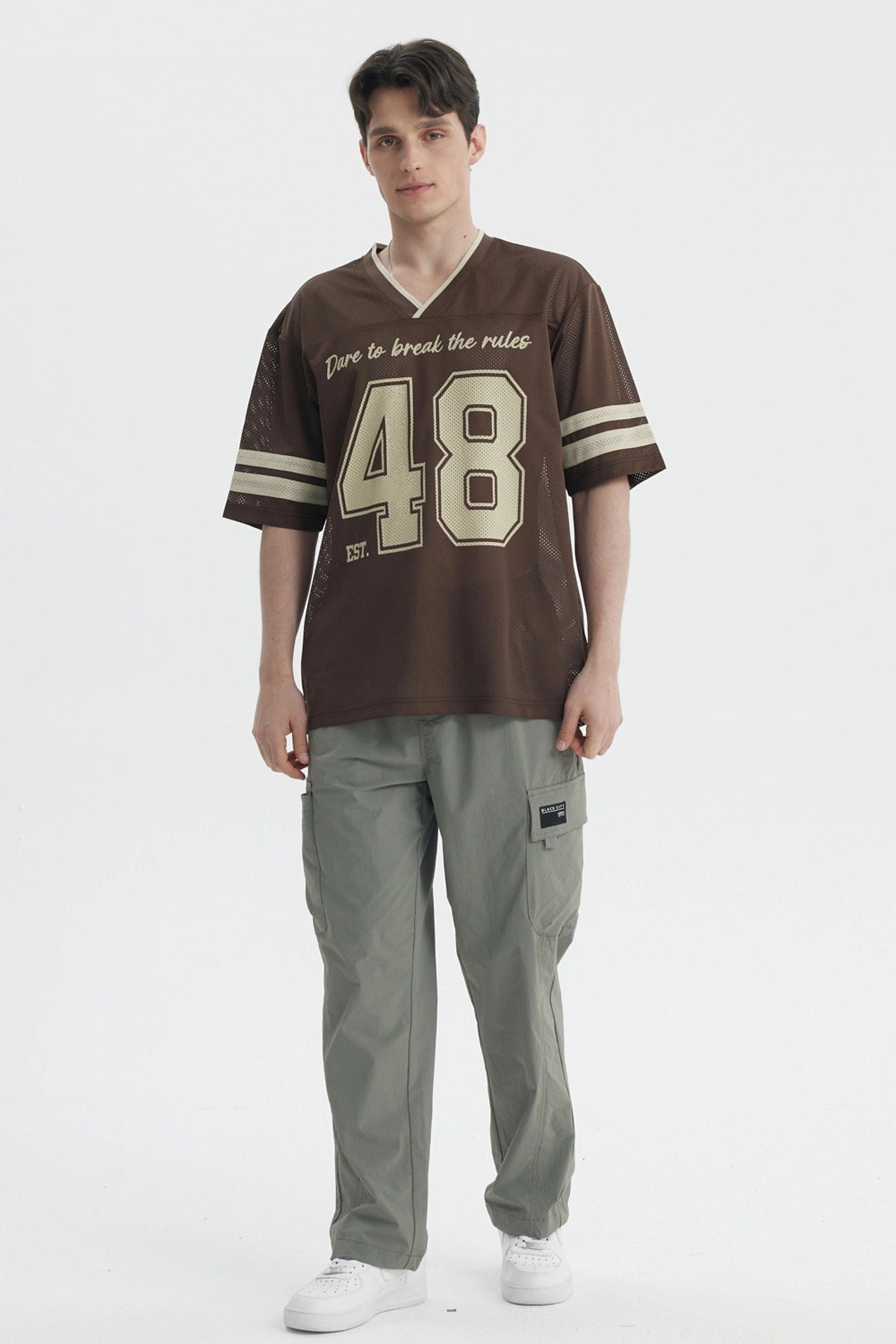 Polera oversize chocolate de hombre con texto Dare to break the rules y n
_x001B__x001B_mero 48 en el frente estilo deportivo