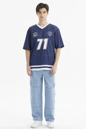Polera oversize azul de hombre con cuello en V blanco y estampa grande del n_x0000_famero 71 en el frente estilo deportivo