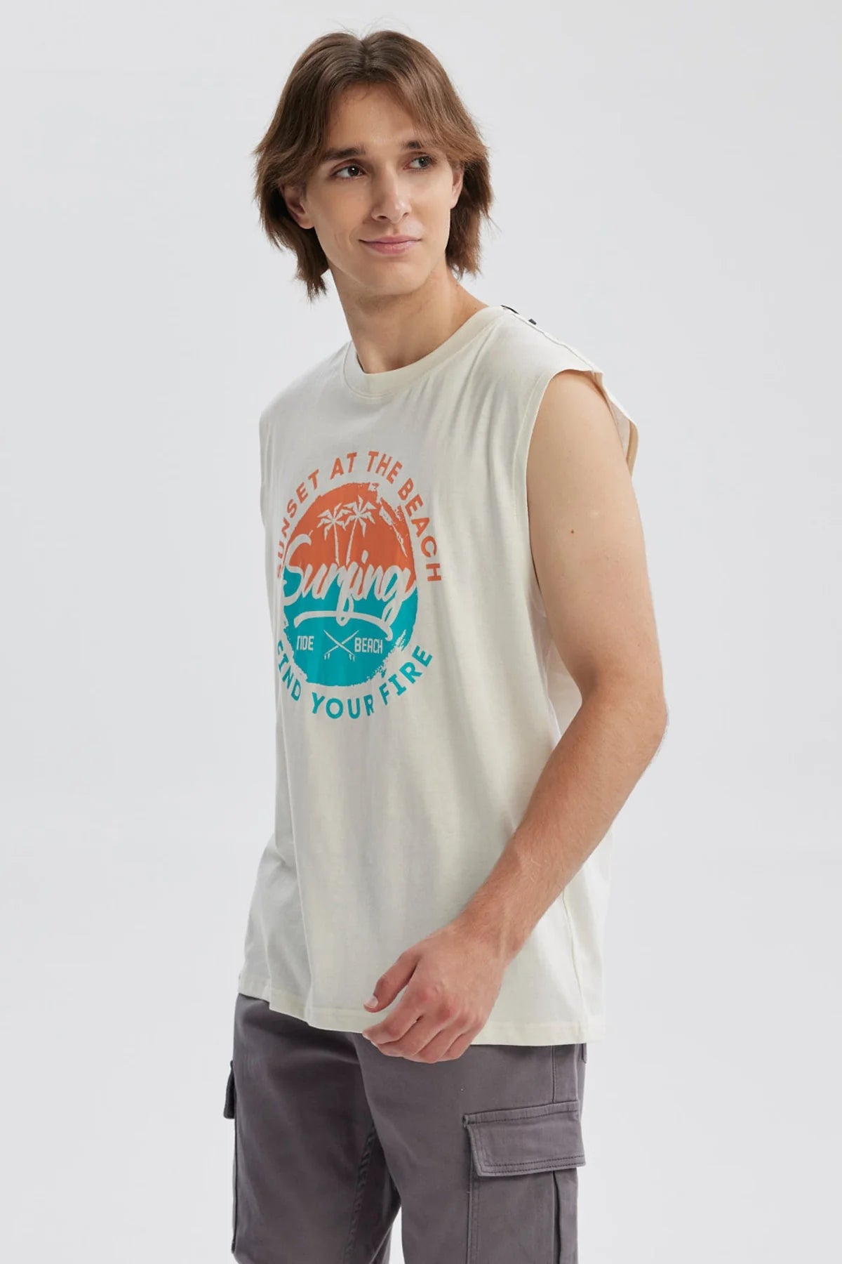 Polera sin mangas beige con estampado de playa y texto en colores vivos