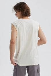 Polera sin mangas beige con estampado de playa y texto en colores vivos