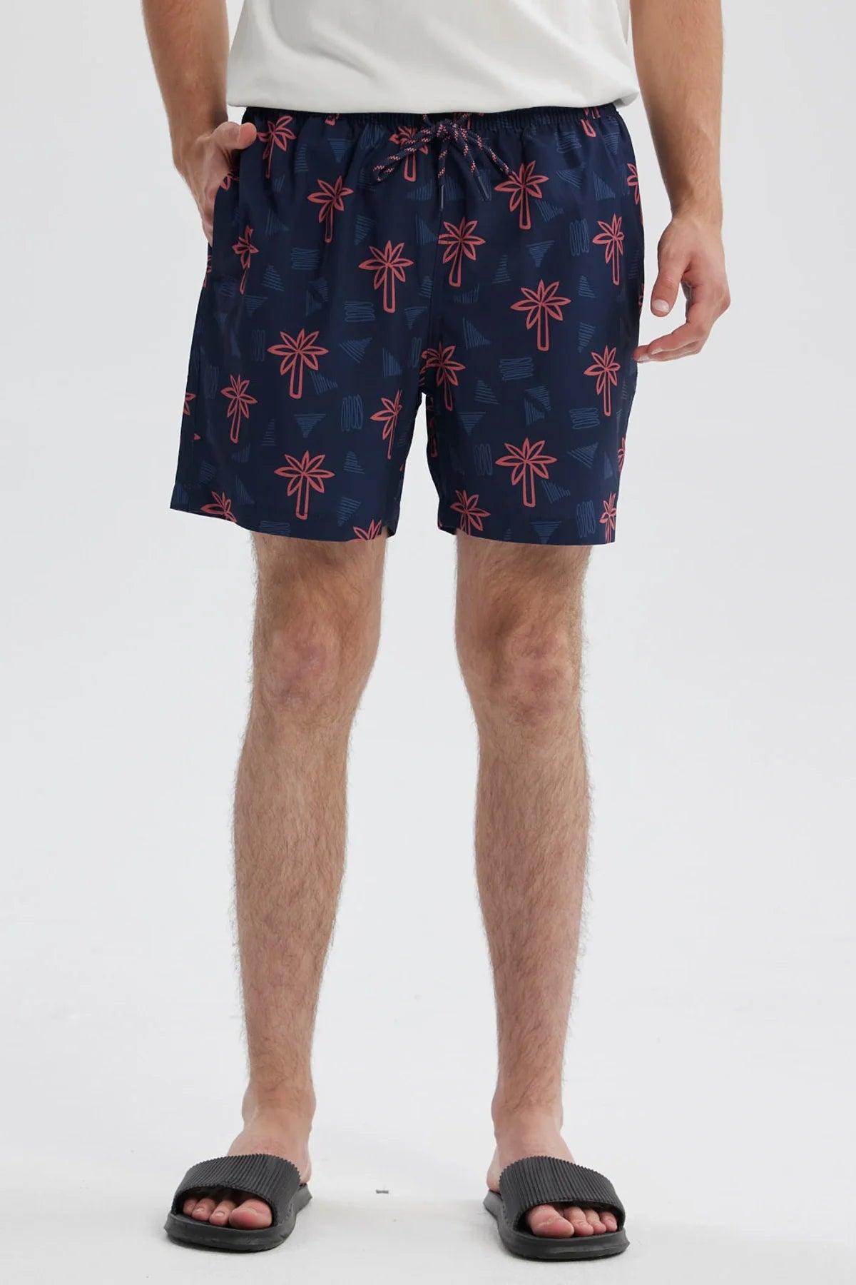 Short de baño azul con estampado de palmeras rojas sobre fondo azul