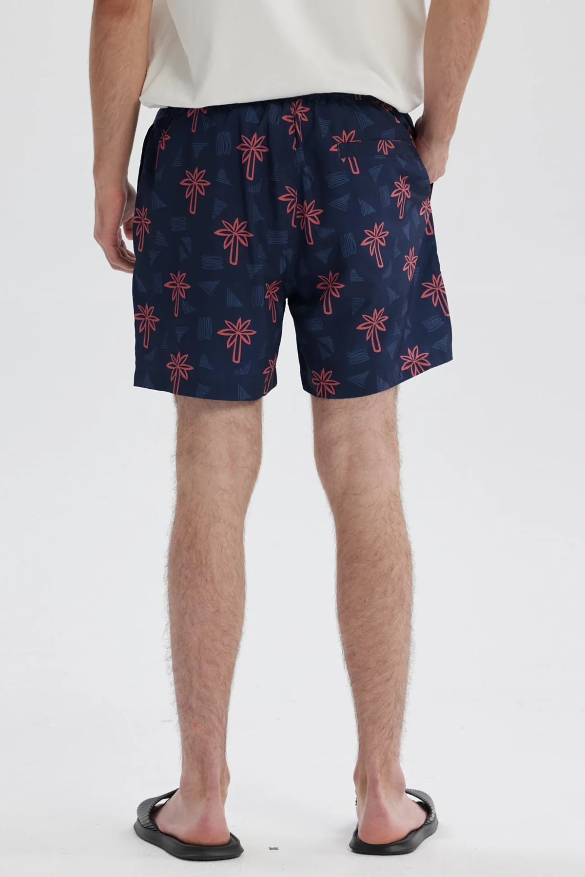 Short de baño azul con estampado de palmeras rojas sobre fondo azul