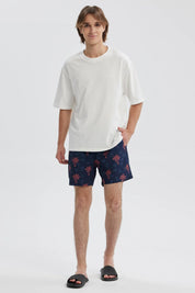 Short de baño azul con estampado de palmeras rojas sobre fondo azul