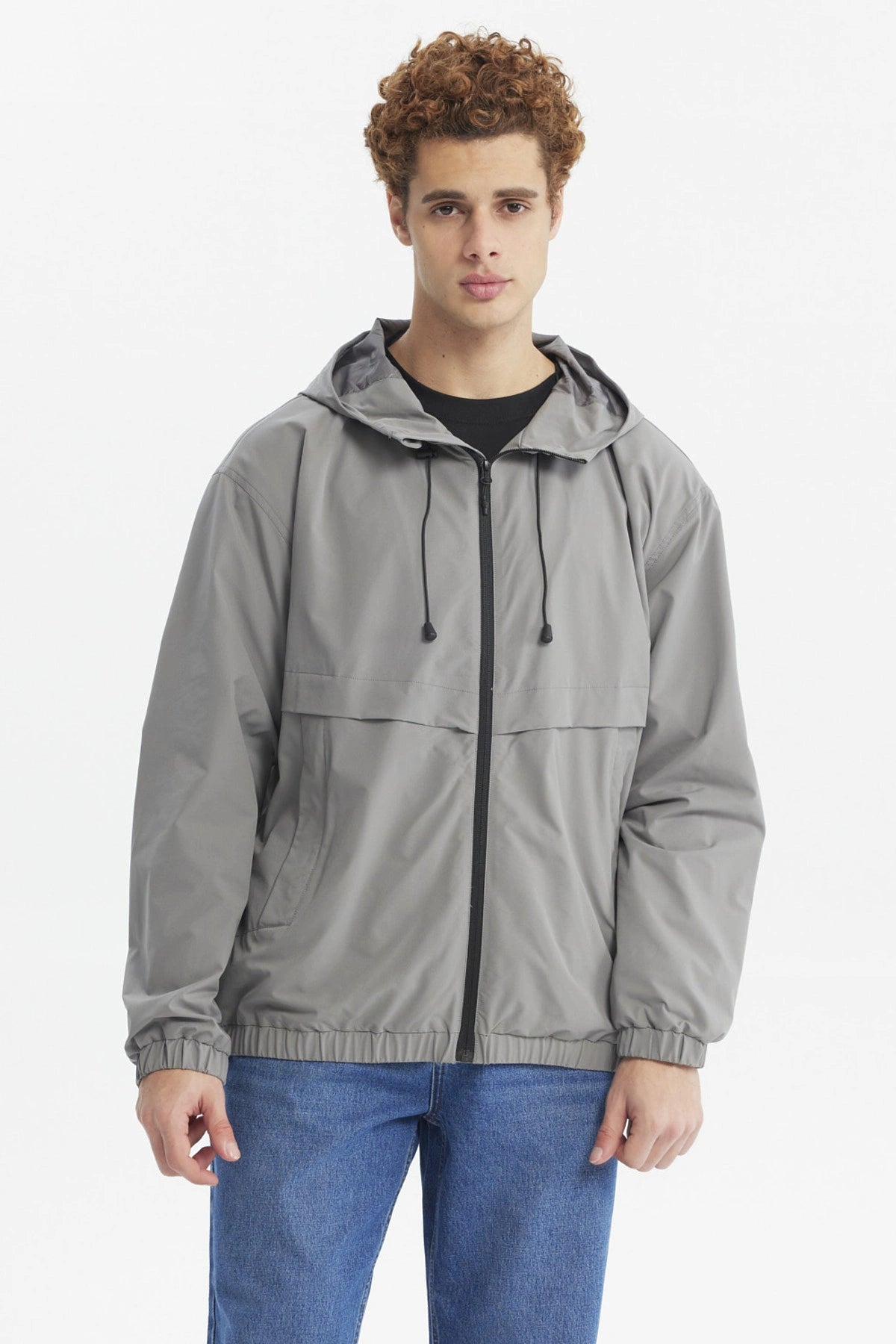 Chaqueta cortaviento gris para hombre con capucha y cierre frontal liso y moderno ideal para días frescos y ventosos