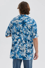 Camisa azul con estampado de hojas blancas y corte clásico de manga corta