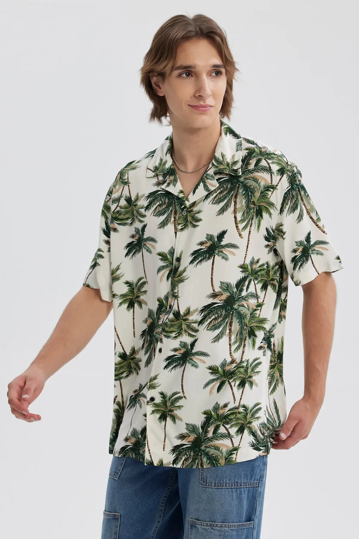 Camisa verde hombre con estampado de palmeras y fondo claro