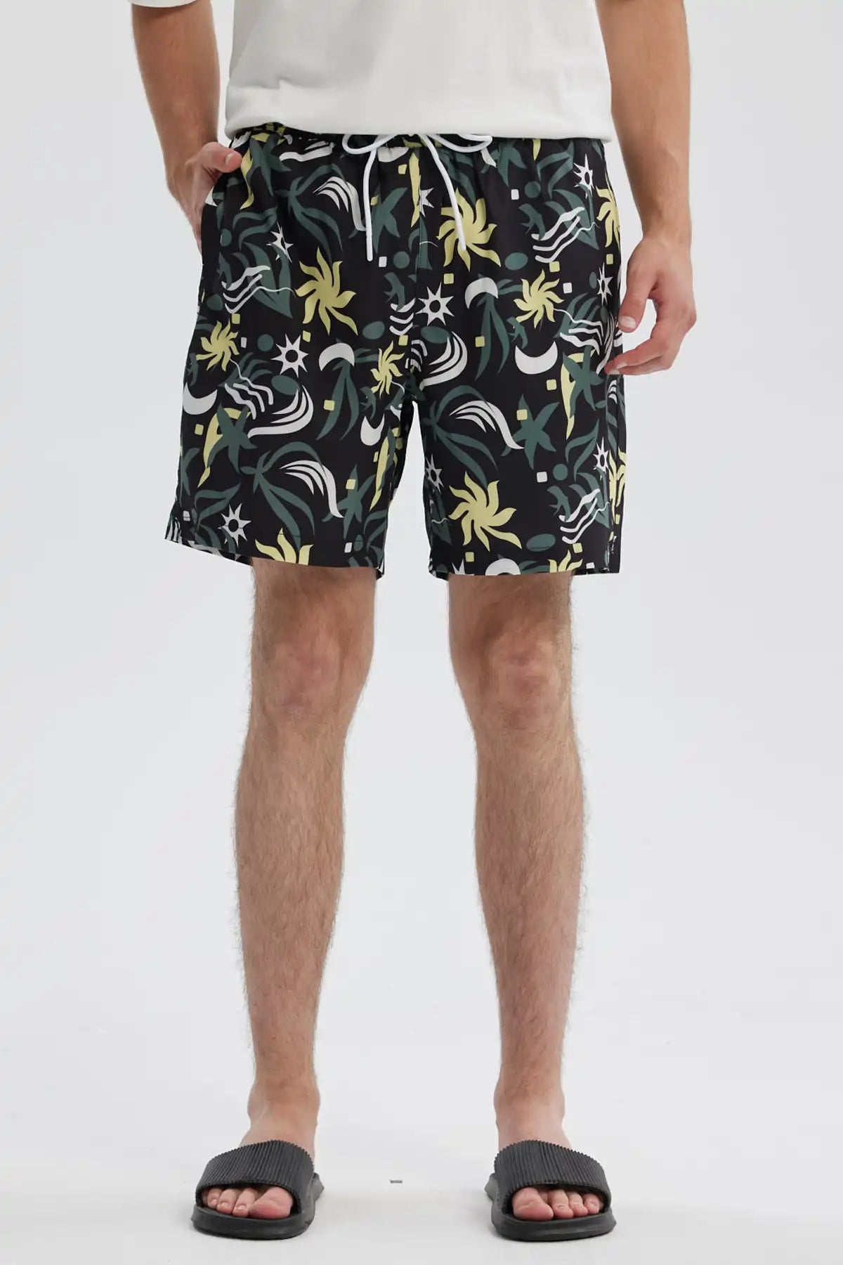 Short de baño negro con estampado geométrico en tonos verdes y amarillos