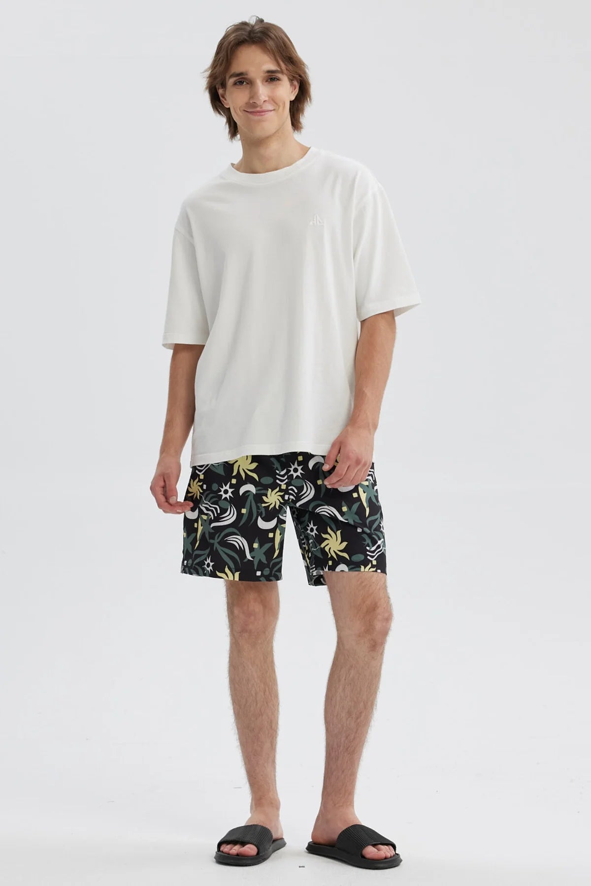 Short de baño negro con estampado geométrico en tonos verdes y amarillos