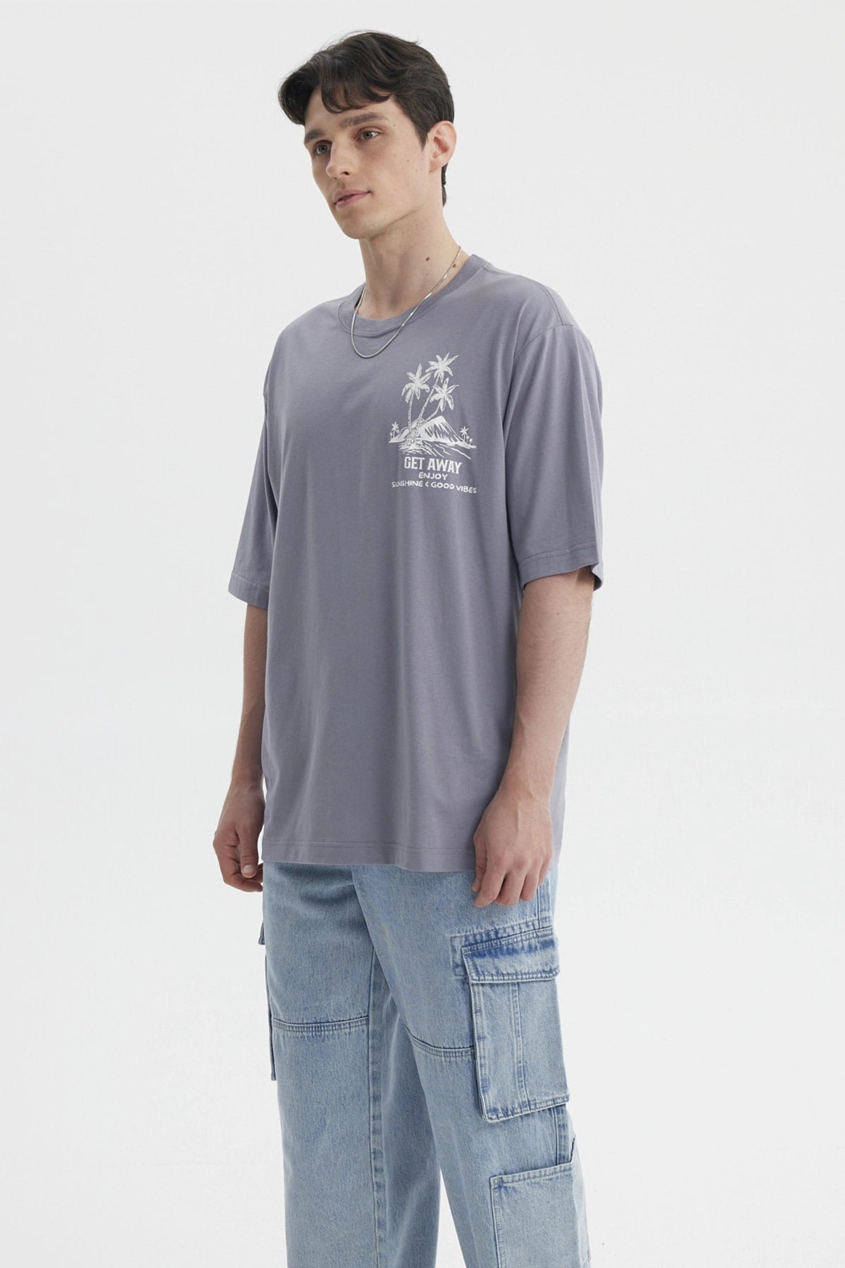 Polera hombre marengo con estampado de palmeras blancas en el pecho estilo tropical relajado