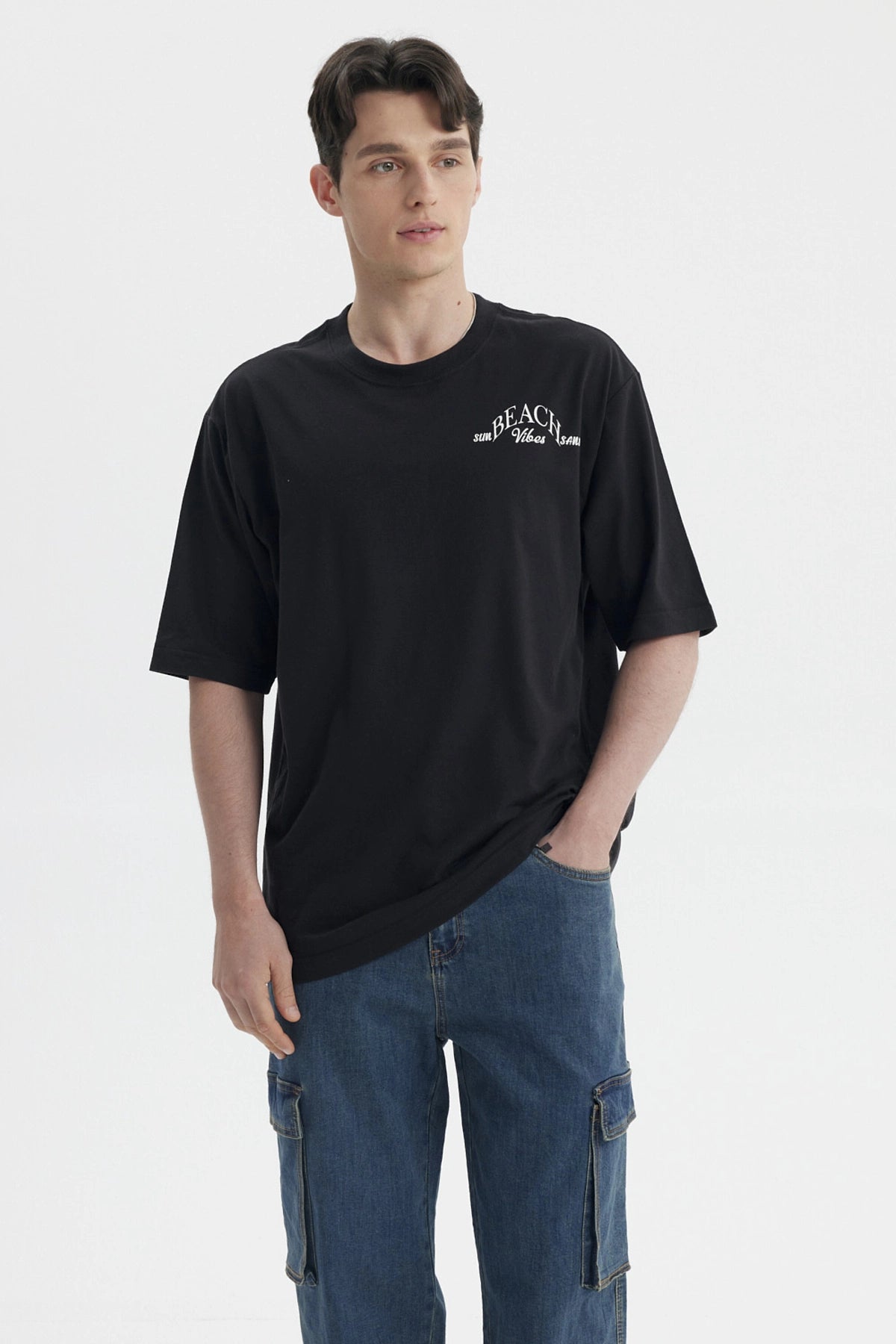 Polera negra de hombre con texto blanco 'Beach Vibes' en el pecho diseño sencillo y relajado sin estampa adicional