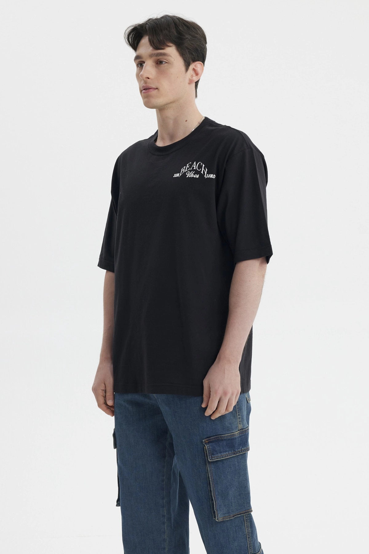 Polera negra de hombre con texto blanco 'Beach Vibes' en el pecho diseño sencillo y relajado sin estampa adicional