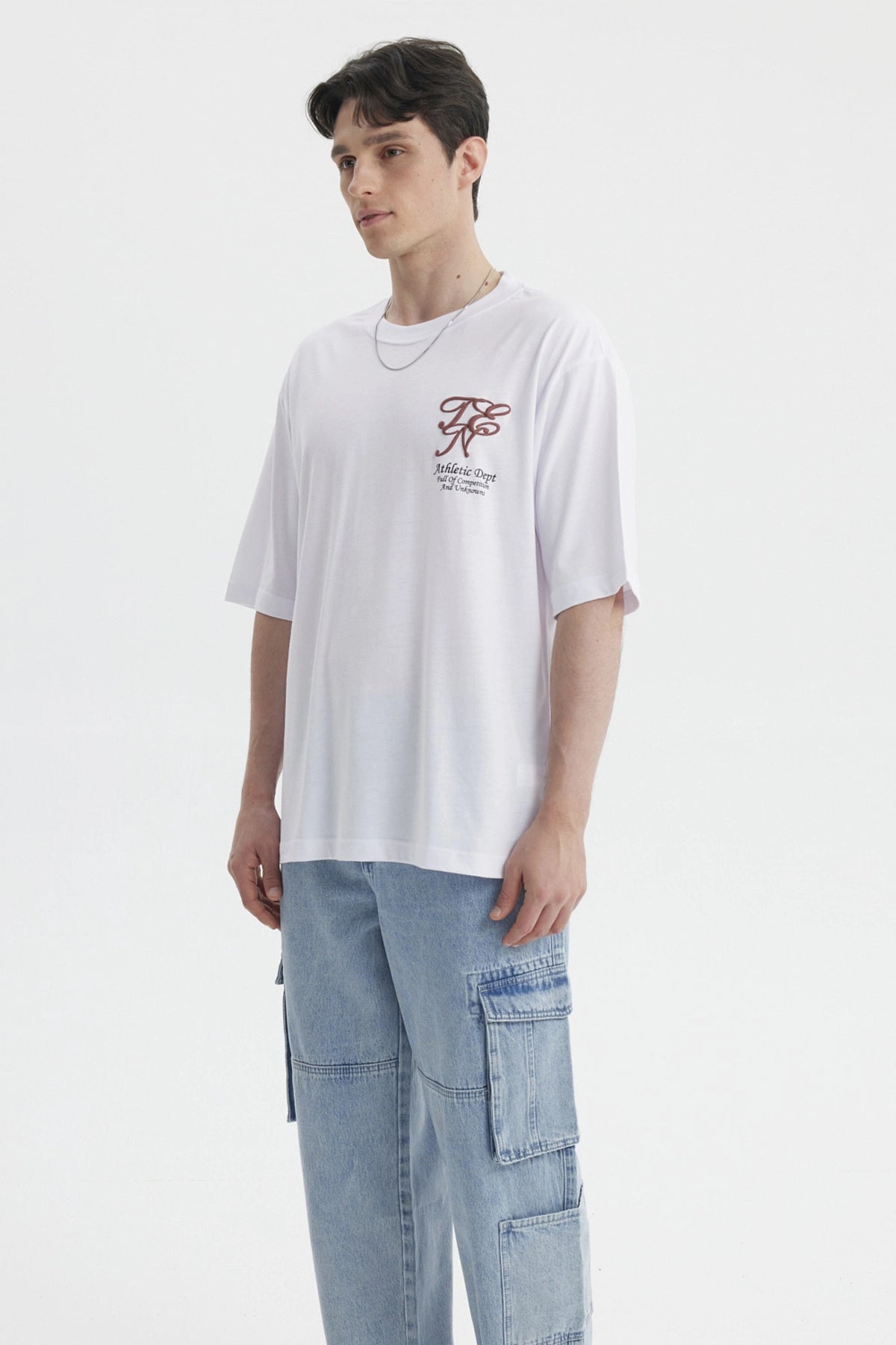 Polera blanca para hombre con estampa en el pecho estilo urbano Athletic Dept con letras grandes en marrón