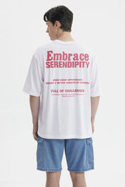 Polera blanca para hombre con texto rosado Embrace Serendipity en el pecho estilo casual y relajado sin estampa adicional