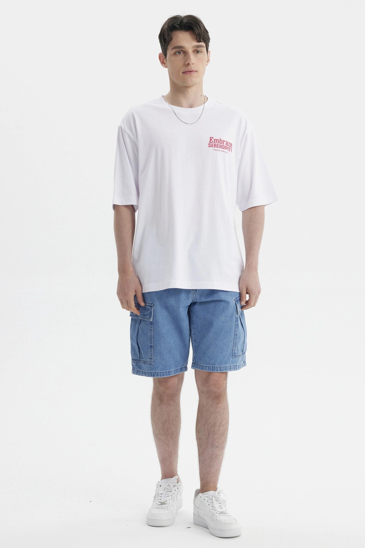 Polera blanca para hombre con texto rosado Embrace Serendipity en el pecho estilo casual y relajado sin estampa adicional