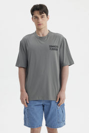 Polera gris para hombre con texto Summer's Flourish en el pecho estilo casual y corte relajado