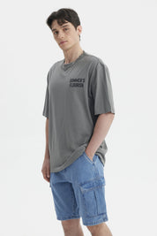 Polera gris para hombre con texto Summer's Flourish en el pecho estilo casual y corte relajado