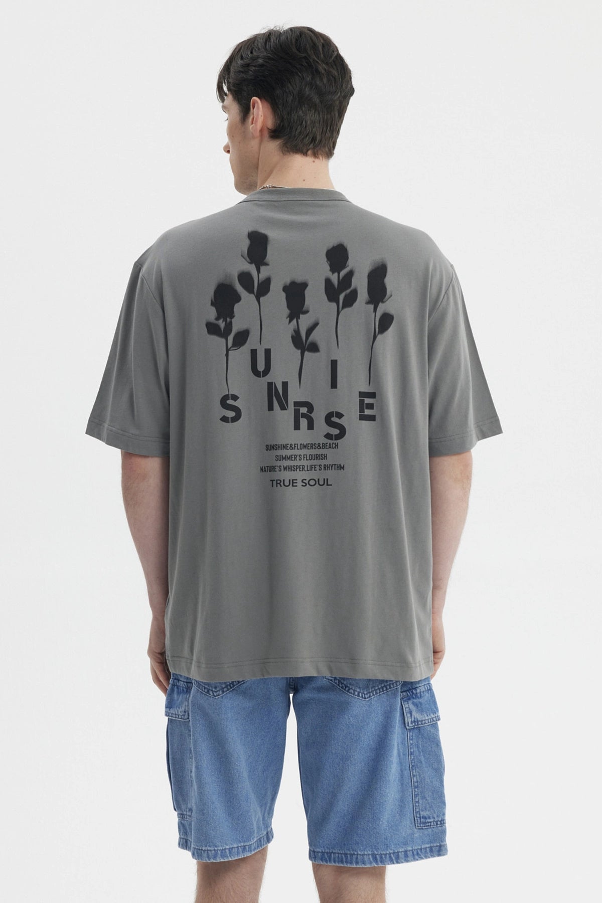 Polera gris para hombre con texto Summer's Flourish en el pecho estilo casual y corte relajado