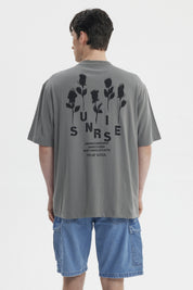 Polera gris para hombre con texto Summer's Flourish en el pecho estilo casual y corte relajado