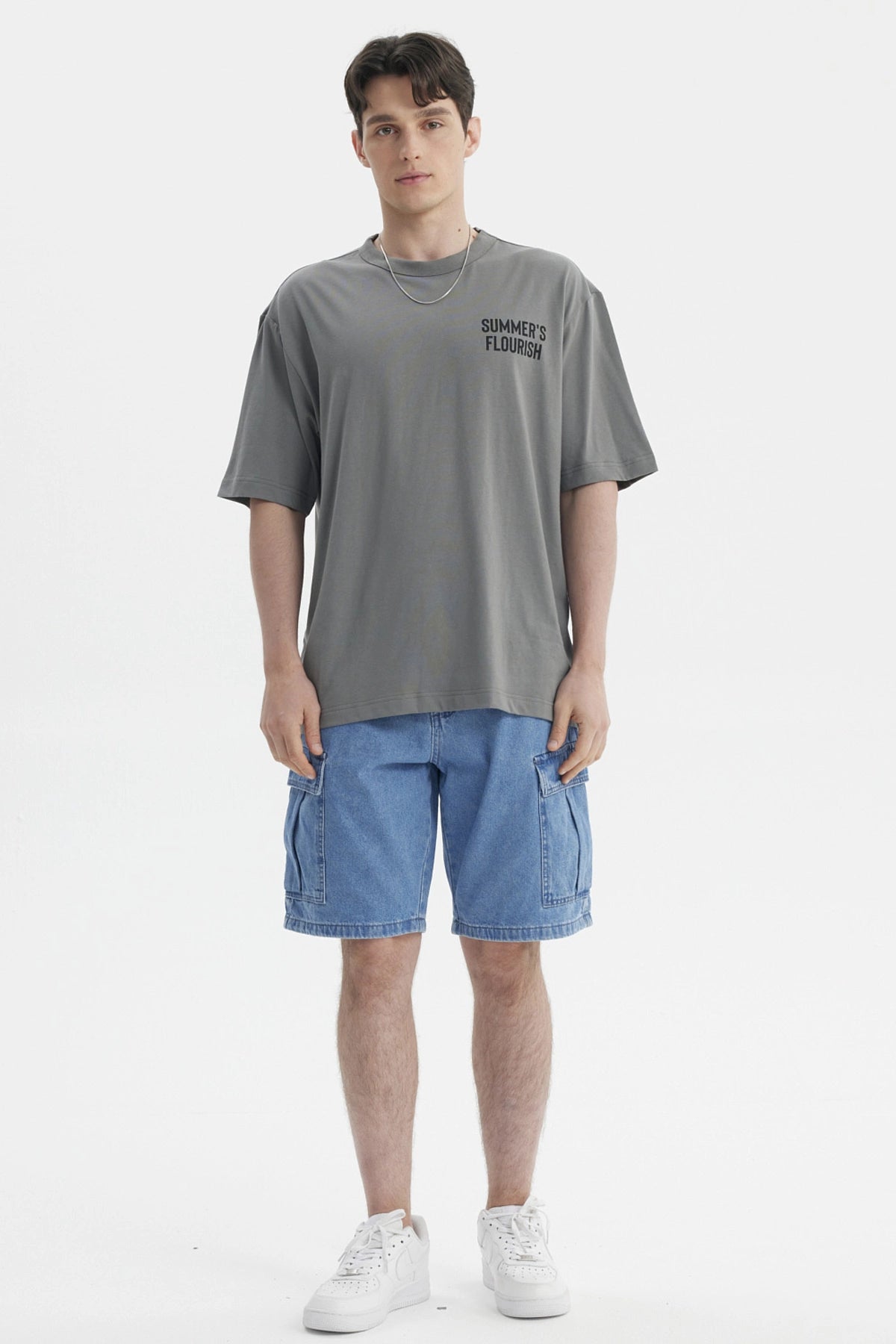 Polera gris para hombre con texto Summer's Flourish en el pecho estilo casual y corte relajado
