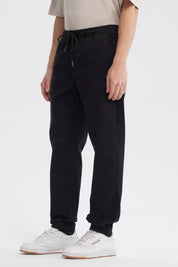Pantalón jogger negro de hombre con cordón en la cintura diseño liso ajuste relajado y puños elásticos en tobillos