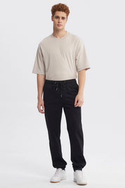 Pantalón jogger negro de hombre con cordón en la cintura diseño liso ajuste relajado y puños elásticos en tobillos