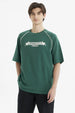 Polera oversize verde para hombre con texto Skateboard Athletic en el pecho estilo deportivo relajado y cómodo