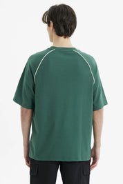 Polera oversize verde para hombre con texto Skateboard Athletic en el pecho estilo deportivo relajado y cómodo