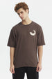 Polera oversize chocolate con estampado pequeño de media luna blanca en el pecho estilo minimalista