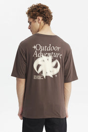 Polera oversize chocolate con estampado pequeño de media luna blanca en el pecho estilo minimalista