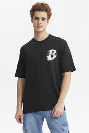 Polera oversize negra con estampado pequeño de letra H y texto Break Through en el pecho diseño moderno y minimalista
