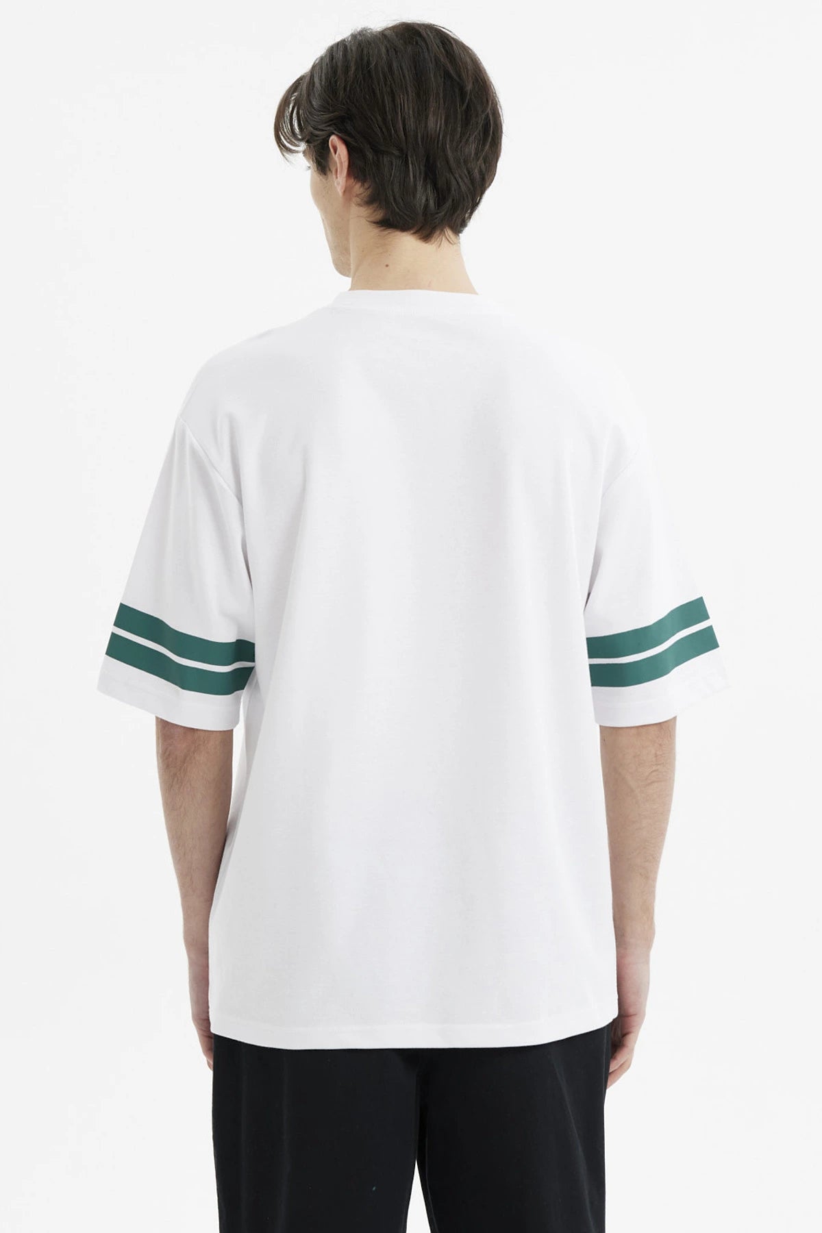 Polera oversize blanca para hombre con texto verde Athletic Sunny Victory al frente estilo casual y rayas en mangas