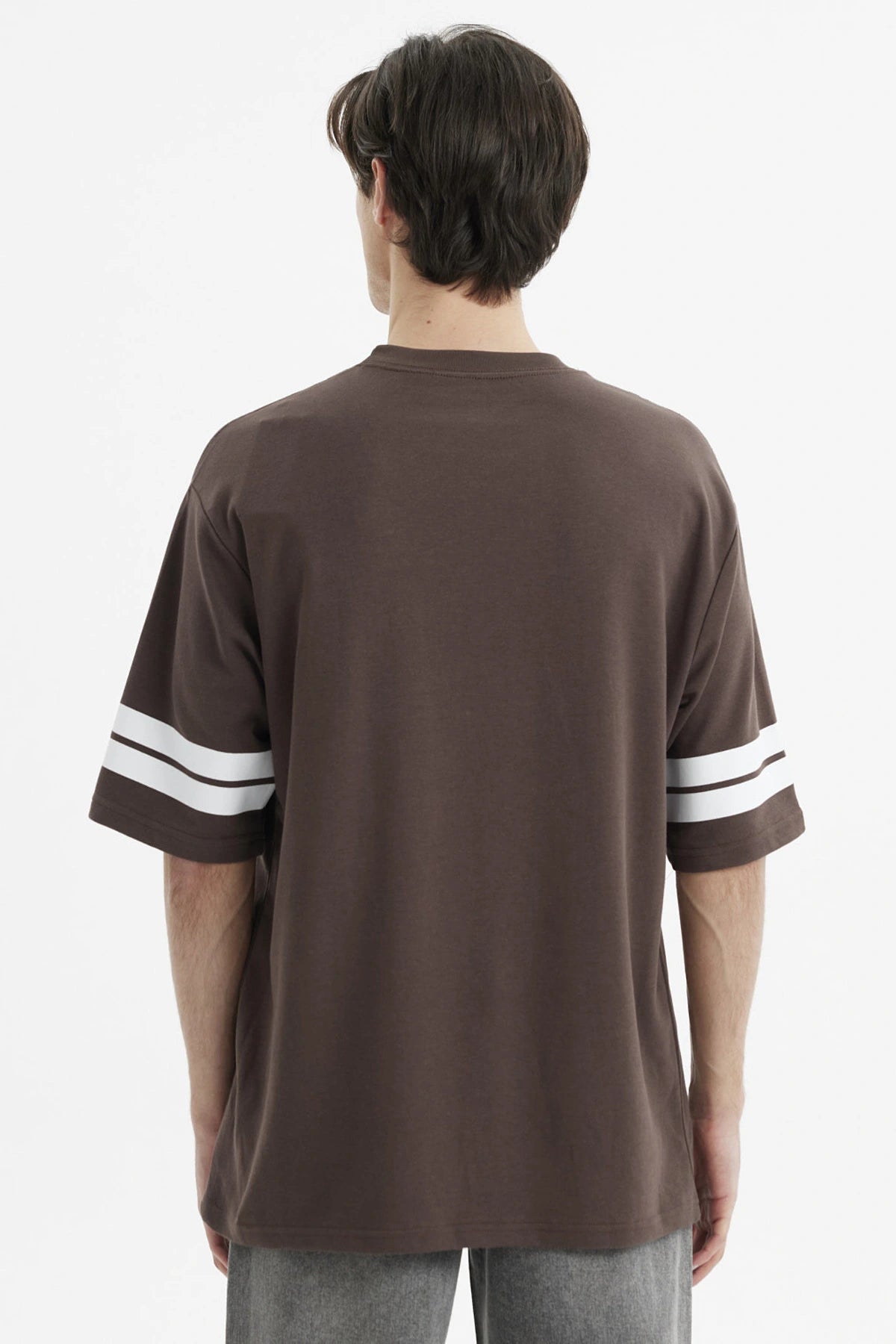 Polera oversize chocolate con estampado frontal California en blanco y rayas en las mangas estilo casual relajado