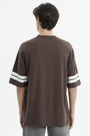 Polera oversize chocolate con estampado frontal California en blanco y rayas en las mangas estilo casual relajado