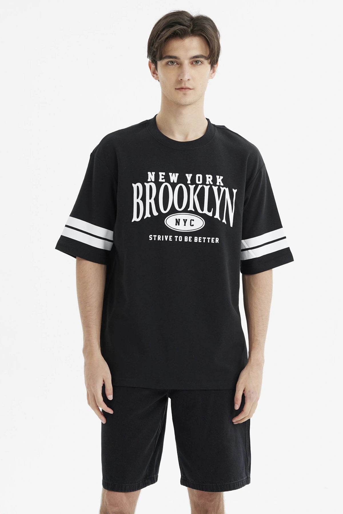Polera oversize negra con estampado frontal New York Brooklyn y texto Strive to be better estilo urbano casual