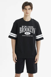 Polera oversize negra con estampado frontal New York Brooklyn y texto Strive to be better estilo urbano casual