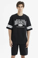 Polera oversize negra con estampado frontal New York Brooklyn y texto Strive to be better estilo urbano casual
