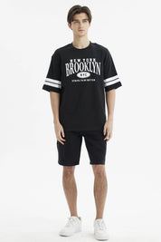 Polera oversize negra con estampado frontal New York Brooklyn y texto Strive to be better estilo urbano casual