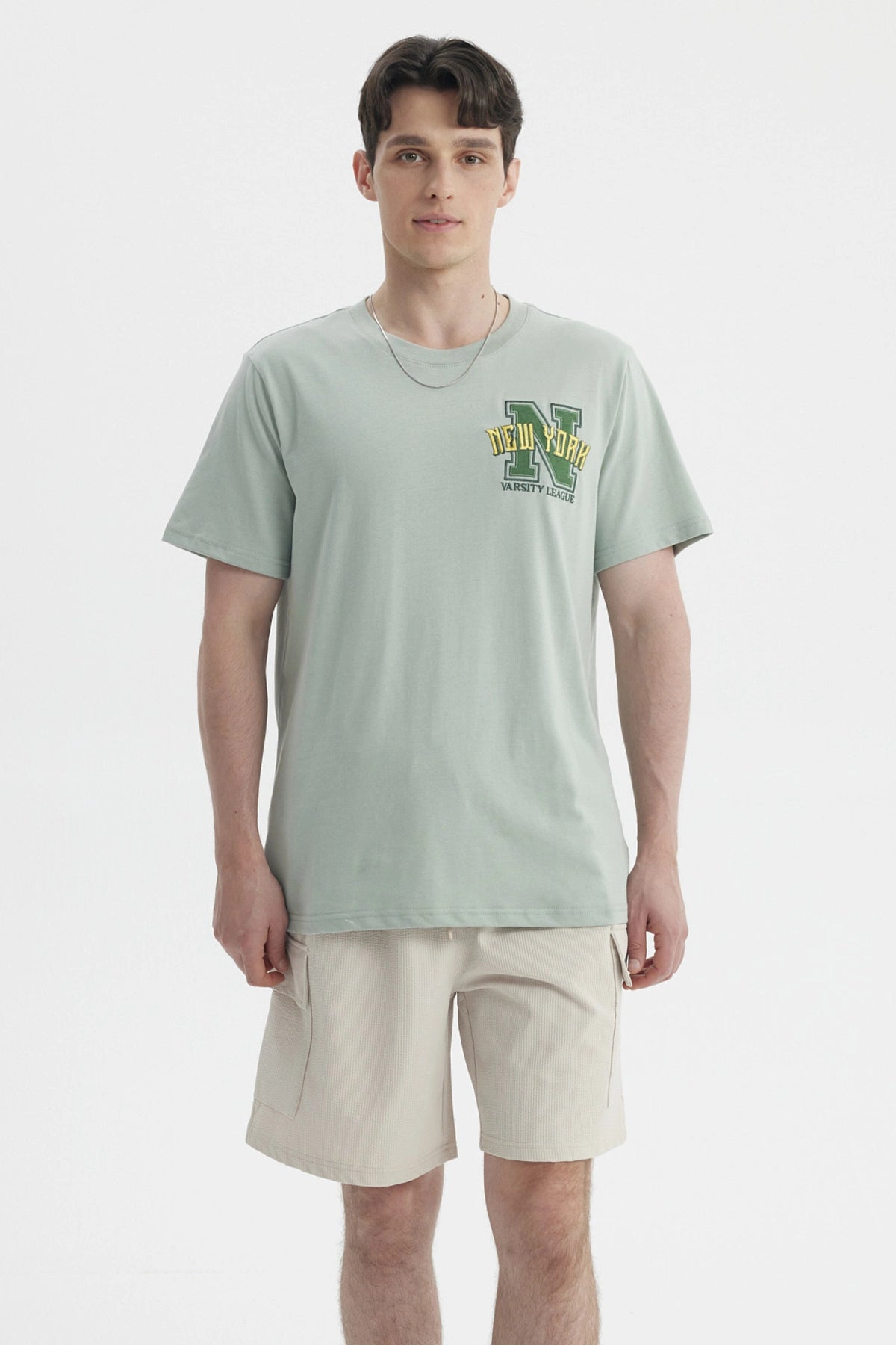 Polera oversize verde claro con bordado New York Varsity League en el pecho estilo casual relajado