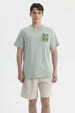 Polera oversize verde claro con bordado New York Varsity League en el pecho estilo casual relajado